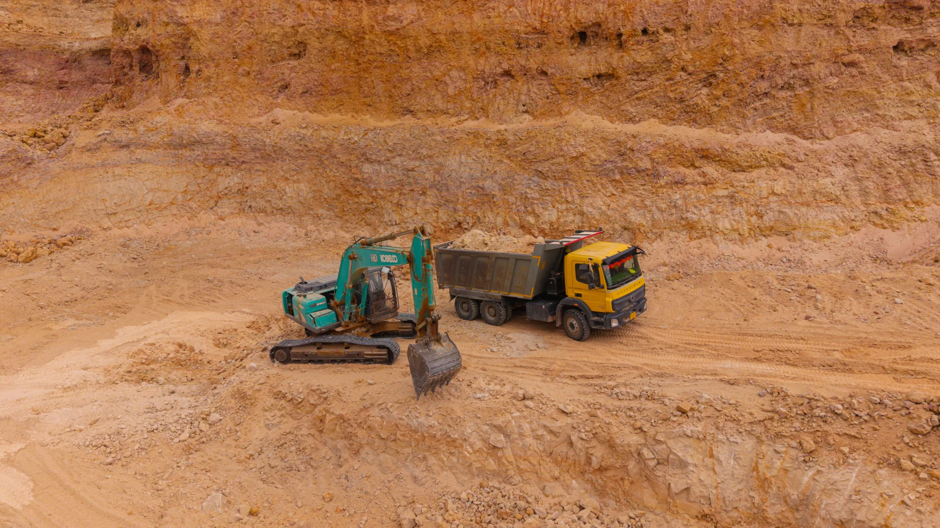Active silica mining operation with excavator and haul truck